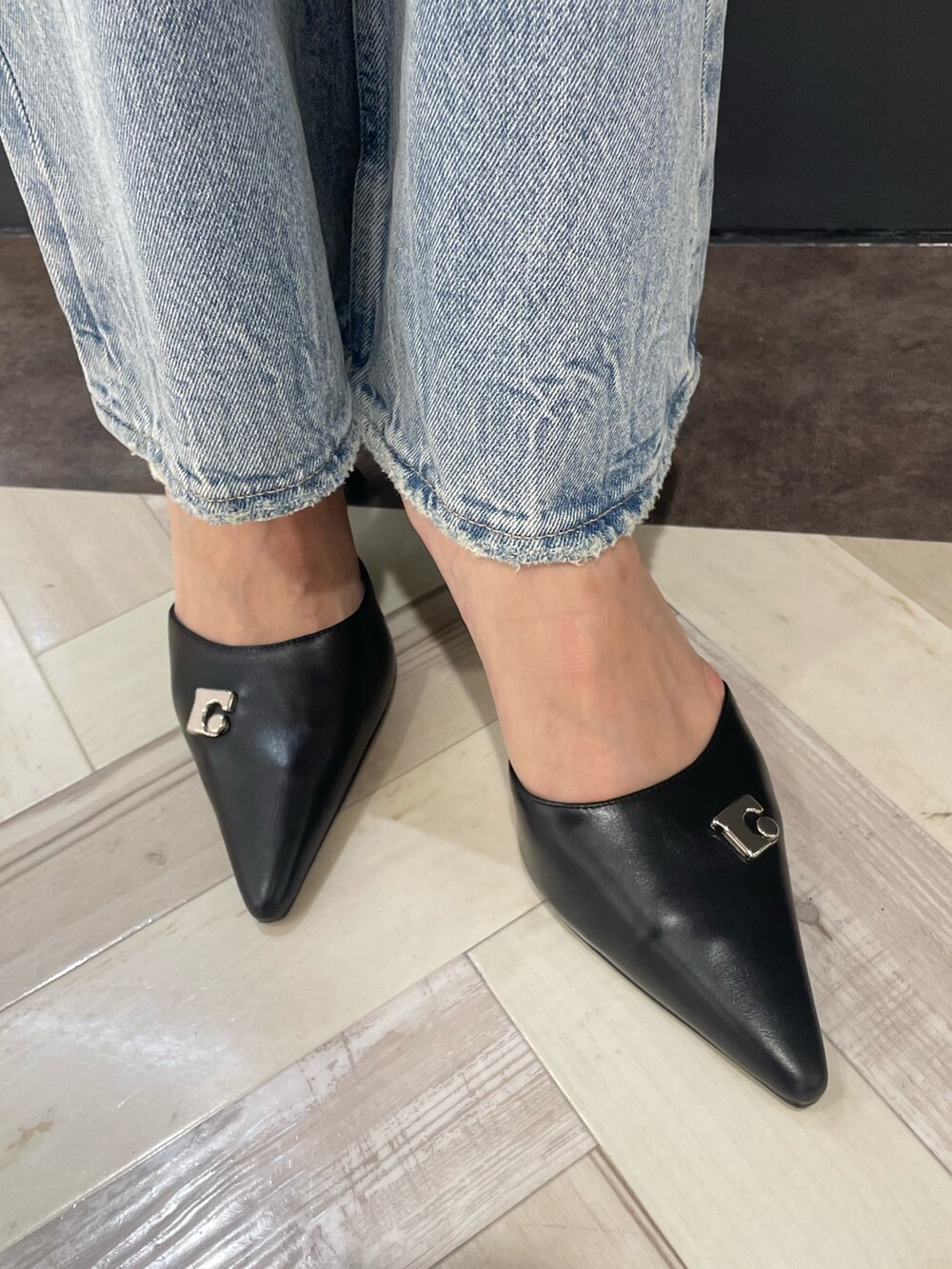 オレンジ系のニット/セーター、ブルー系のデニムパンツ、ブラック系のパンプスを着用したレディースの春コーディネートの10枚目の写真