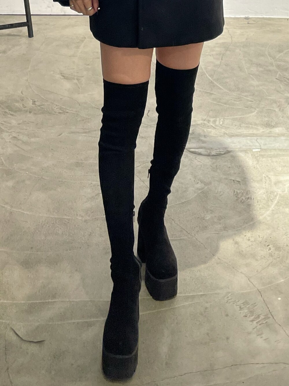 ブラック系のピーコート、グレー系のワンピース、ブラック系のブーツを着用したレディースの冬コーディネートの8枚目の写真