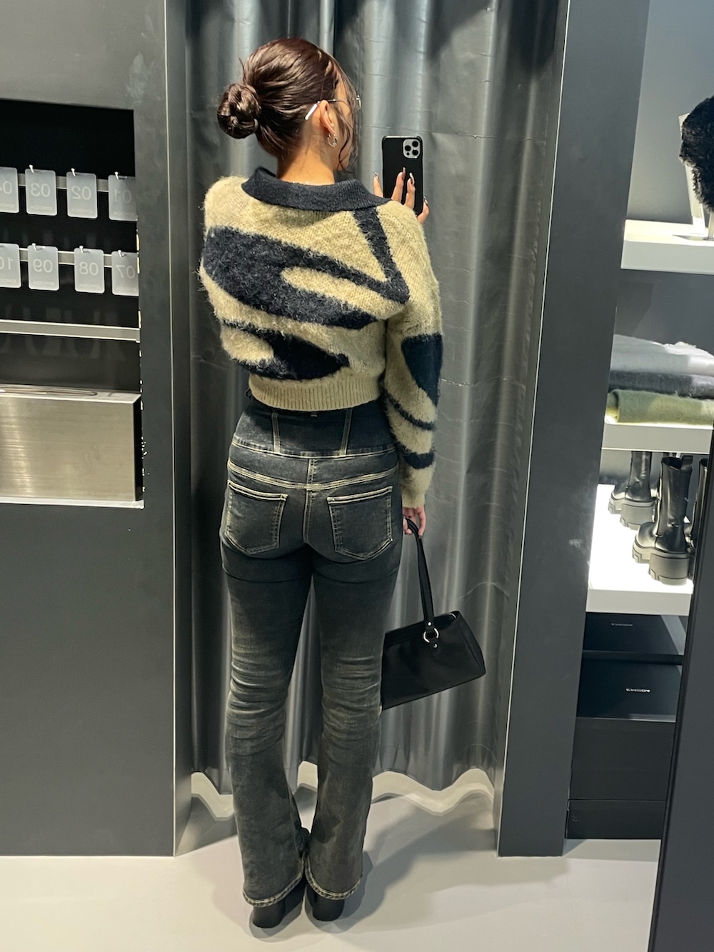 ブルー系のニット/セーター、ブルー系のデニムパンツ、ブラック系のショルダーバッグを着用したレディースの冬コーディネートの3枚目の写真