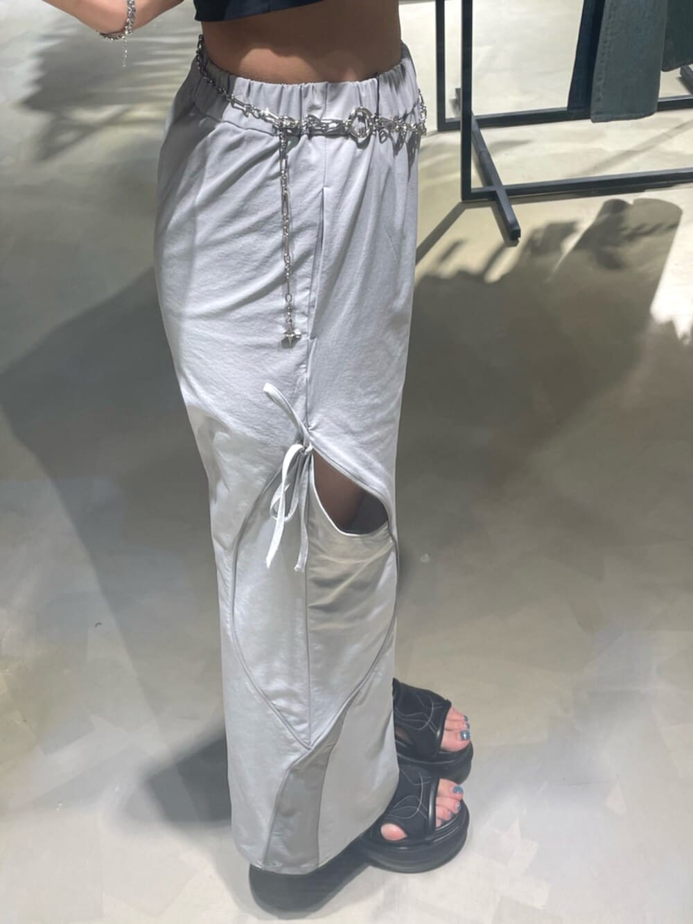 ブラック系のTシャツ/カットソー、グレー系のその他パンツ、ブラック系のサンダルを着用したレディースの春コーディネートの7枚目の写真