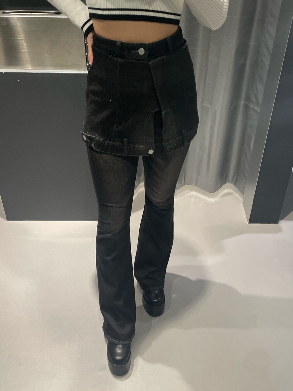 ホワイト系のニット/セーター、ブラック系のデニムパンツ、ブラック系のブーツを着用したレディースの秋コーディネートの6枚目の写真