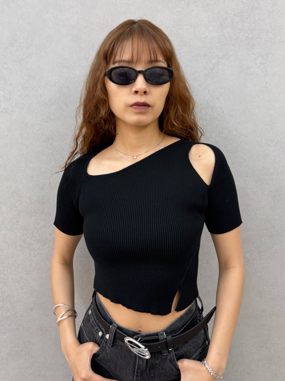 ブラック系のニット/セーター、ブラック系のデニムパンツ、ブラック系のサンダルを着用したレディースの夏コーディネートの4枚目の写真