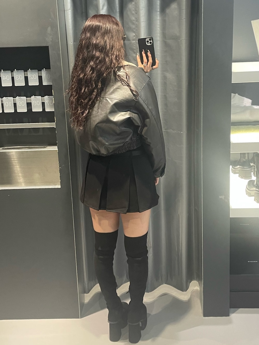 グレー系のブルゾン、ブラック系のTシャツ/カットソー、ブラック系のスカートを着用したレディースの冬コーディネートの3枚目の写真