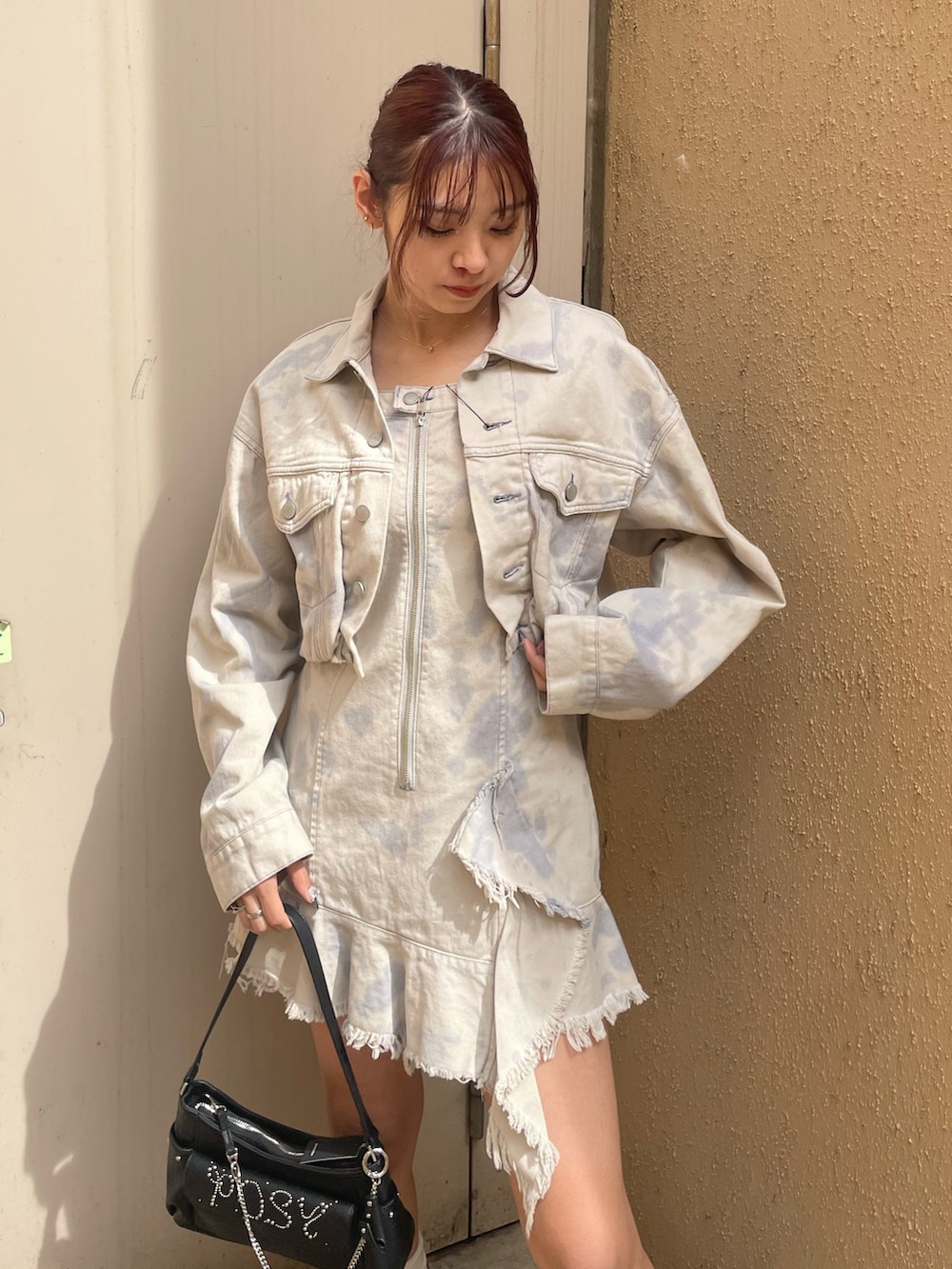 ホワイト系のデニムジャケット、ホワイト系のワンピース、ブラック系のハンドバッグを着用したレディースの春コーディネートの4枚目の写真