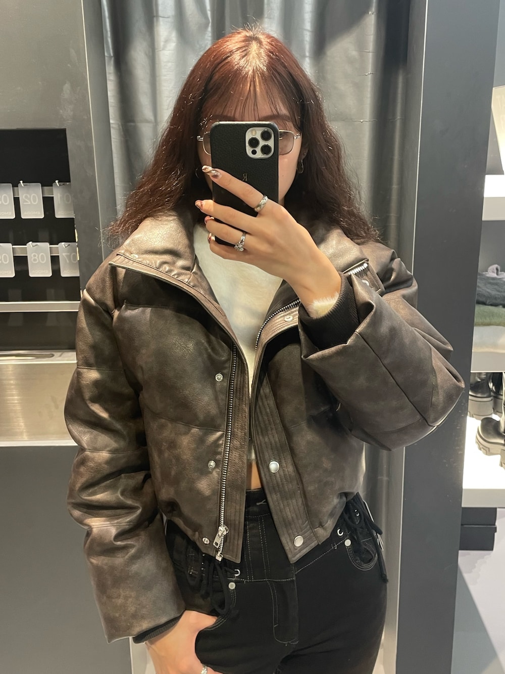 ホワイト系のニット/セーター、ブラウン系のダウンジャケット/コート、ブラック系のデニムパンツを着用したレディースの冬コーディネートの4枚目の写真