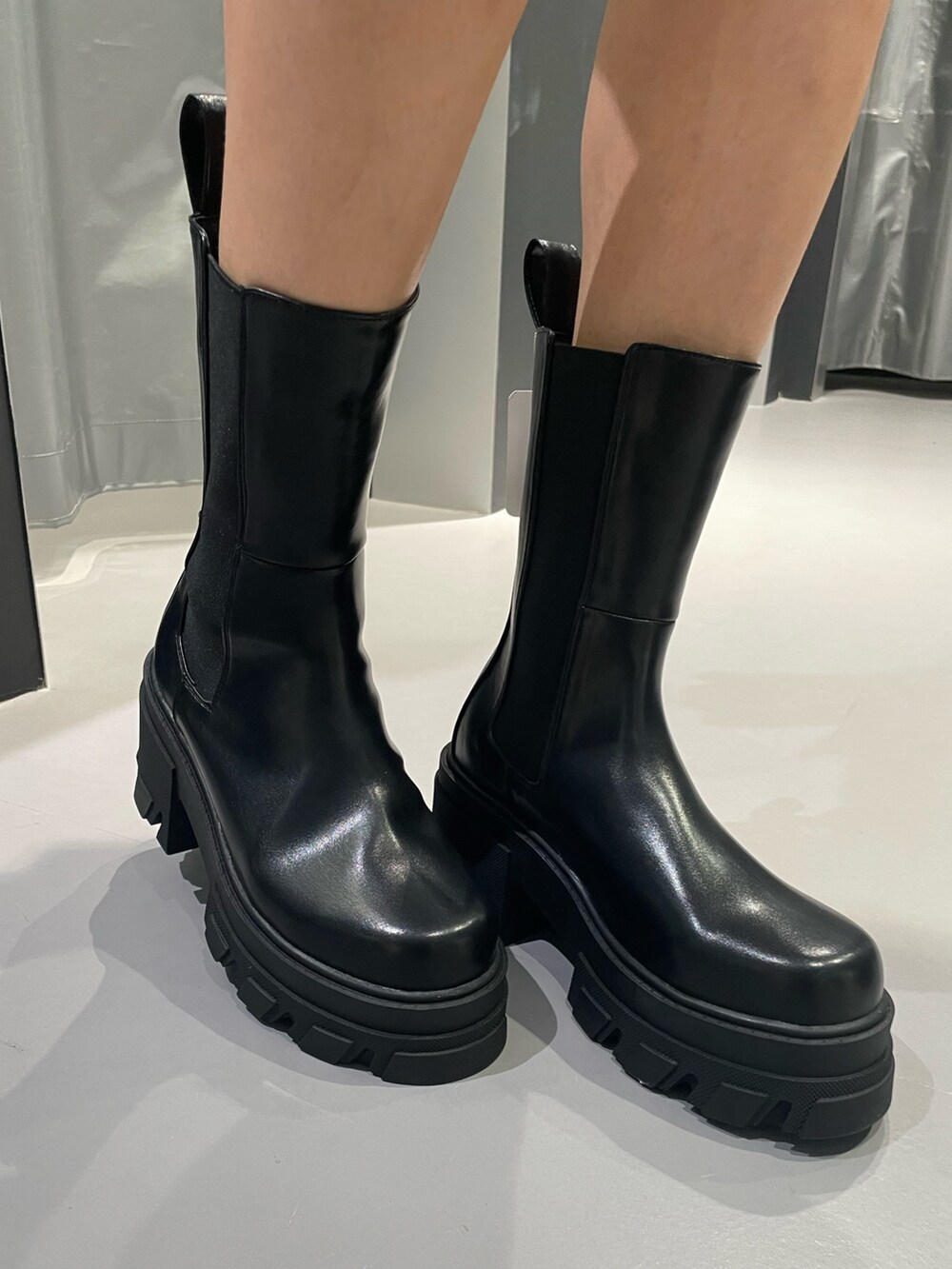 グレー系のニット/セーター、グレー系のスカート、ブラック系のショルダーバッグを着用したレディースの冬コーディネートの9枚目の写真