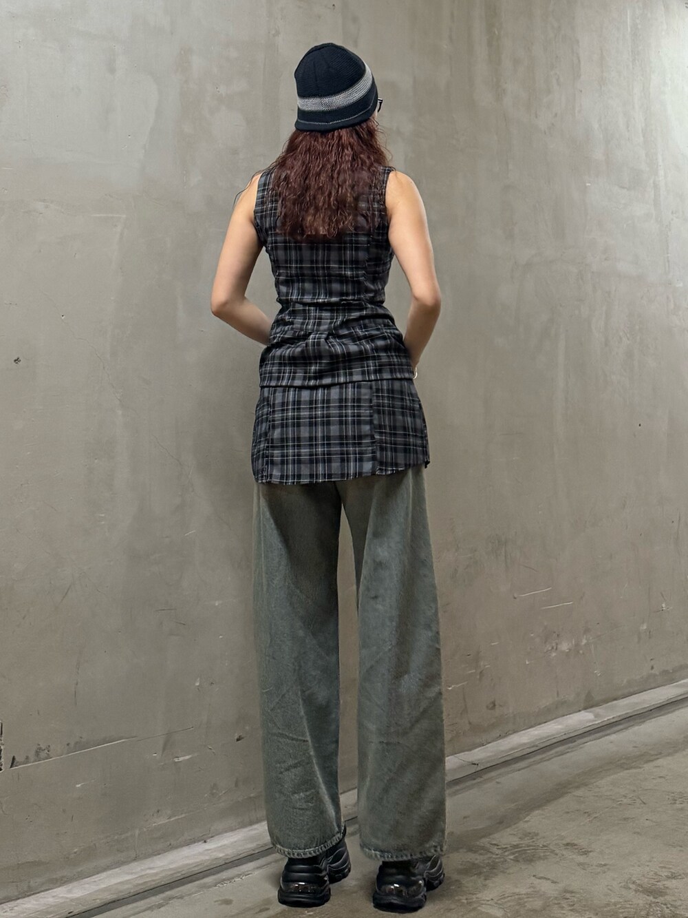 グレー系のワンピース、ブルー系のデニムパンツ、ブラック系のサンダルを着用したレディースの夏コーディネートの3枚目の写真