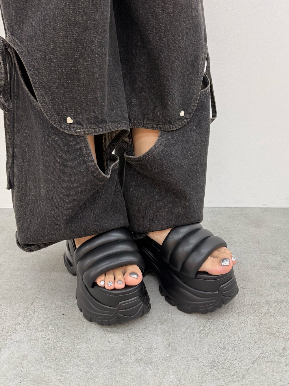 ブラック系のニット/セーター、ブラック系のデニムパンツ、ブラック系のサンダルを着用したレディースの夏コーディネートの10枚目の写真