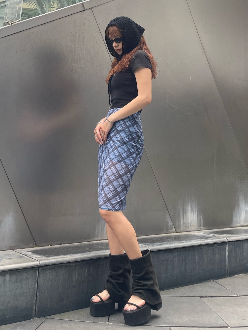 ブラック系のTシャツ/カットソー、ブルー系のスカート、ブラック系のサンダルを着用したレディースの夏コーディネートの2枚目の写真