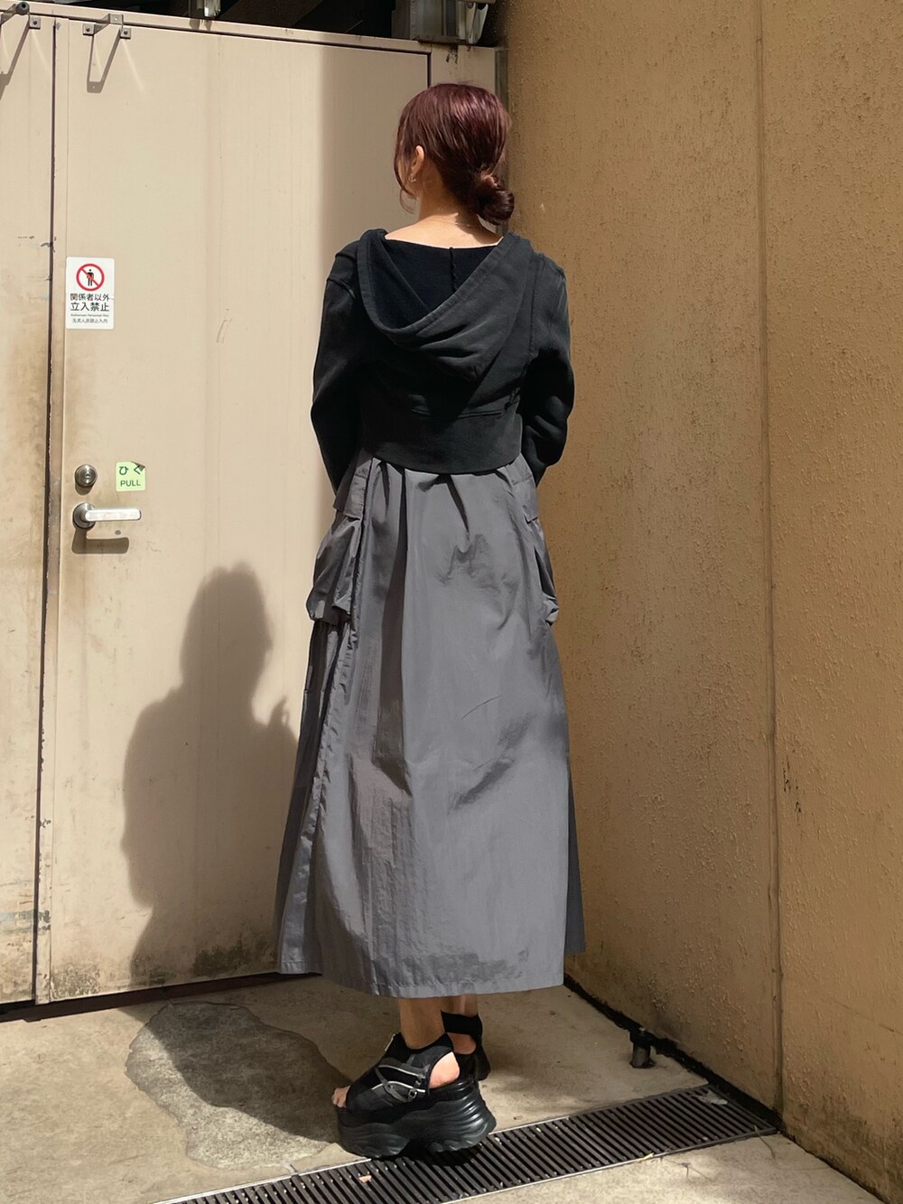 ブラック系のTシャツ/カットソー、グレー系のワンピース、ブラック系のサンダルを着用したレディースの春コーディネートの3枚目の写真