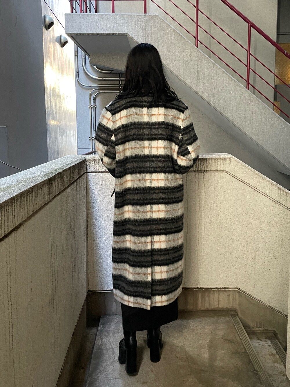 グレー系のニット/セーター、その他のチェスターコート、ブラック系のスカートを着用したレディースの冬コーディネートの3枚目の写真