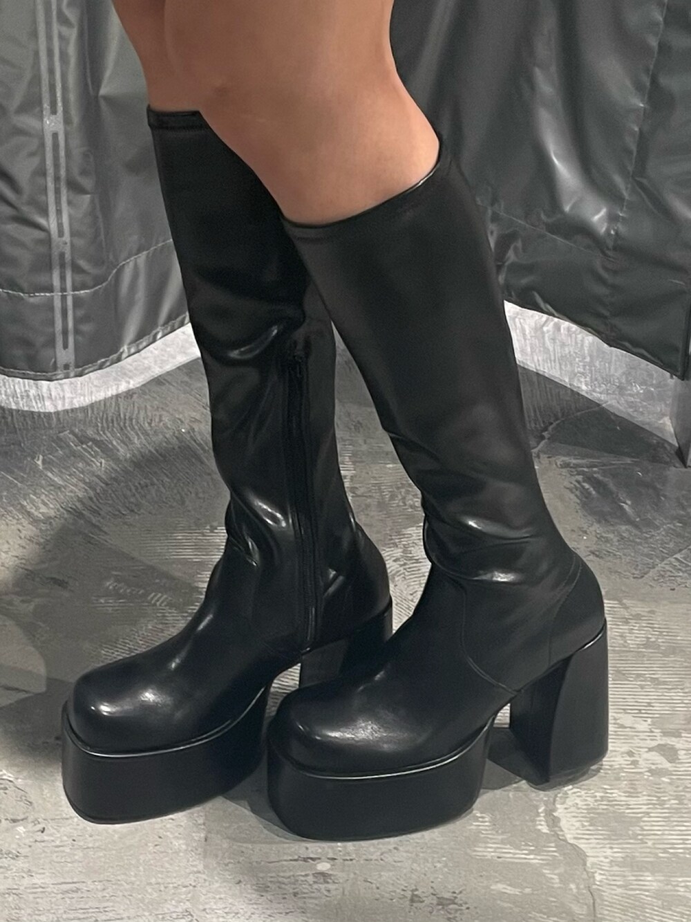 ブラック系のブルゾン、グレー系のワンピース、ブラック系のブーツを着用したレディースの秋コーディネートの10枚目の写真