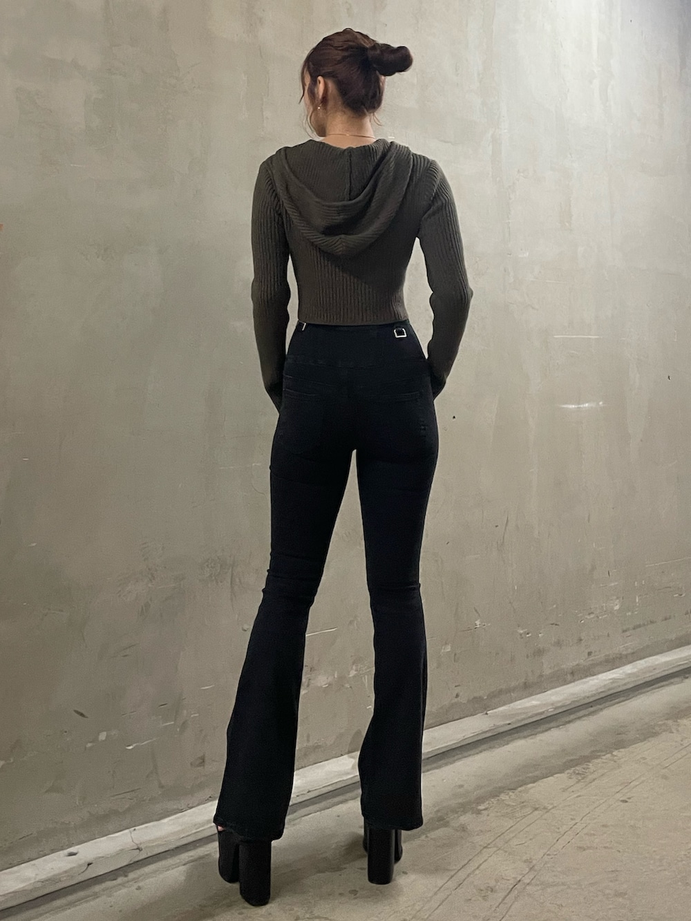 グリーン系のニット/セーター、ブラック系のデニムパンツ、ブラック系のサンダルを着用したレディースの春コーディネートの3枚目の写真