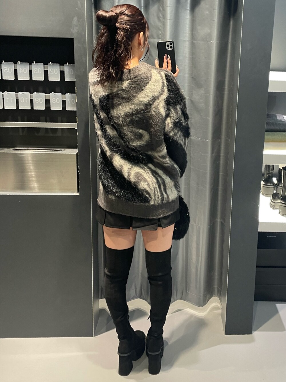 グレー系のニット/セーター、ブラック系のスカート、ブラック系のハンドバッグを着用したレディースの冬コーディネートの3枚目の写真