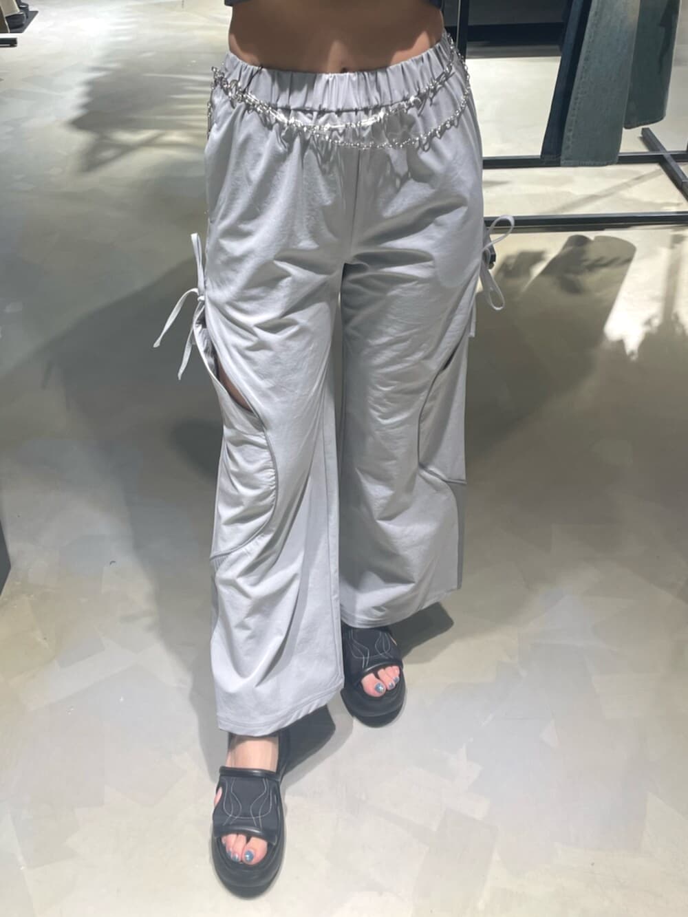 ブラック系のTシャツ/カットソー、グレー系のその他パンツ、ブラック系のサンダルを着用したレディースの春コーディネートの6枚目の写真