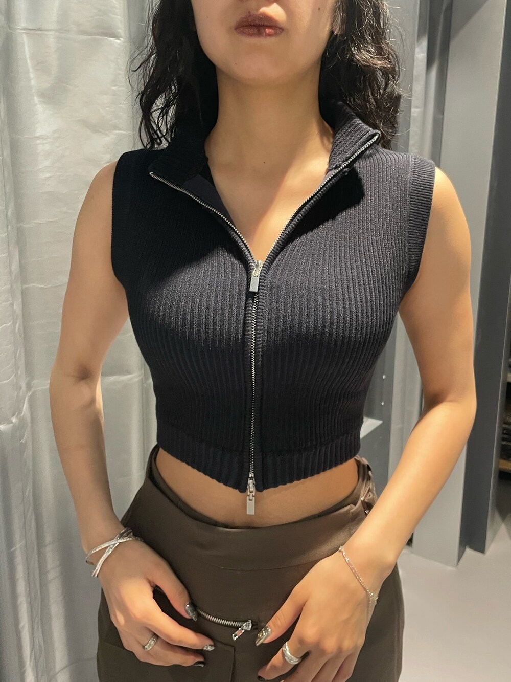 ブラック系のニット/セーター、ブラウン系のその他パンツ、ブラック系のサンダルを着用したレディースの夏コーディネートの4枚目の写真