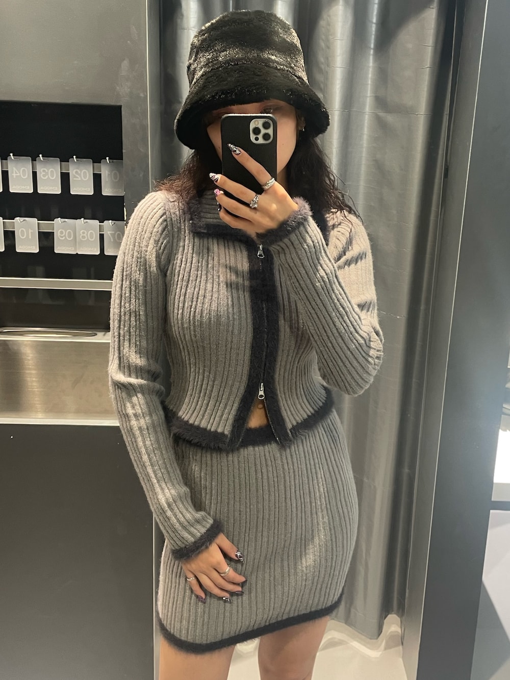 グレー系のニット/セーター、グレー系のスカート、ブラック系のブーツを着用したレディースの秋コーディネートの4枚目の写真