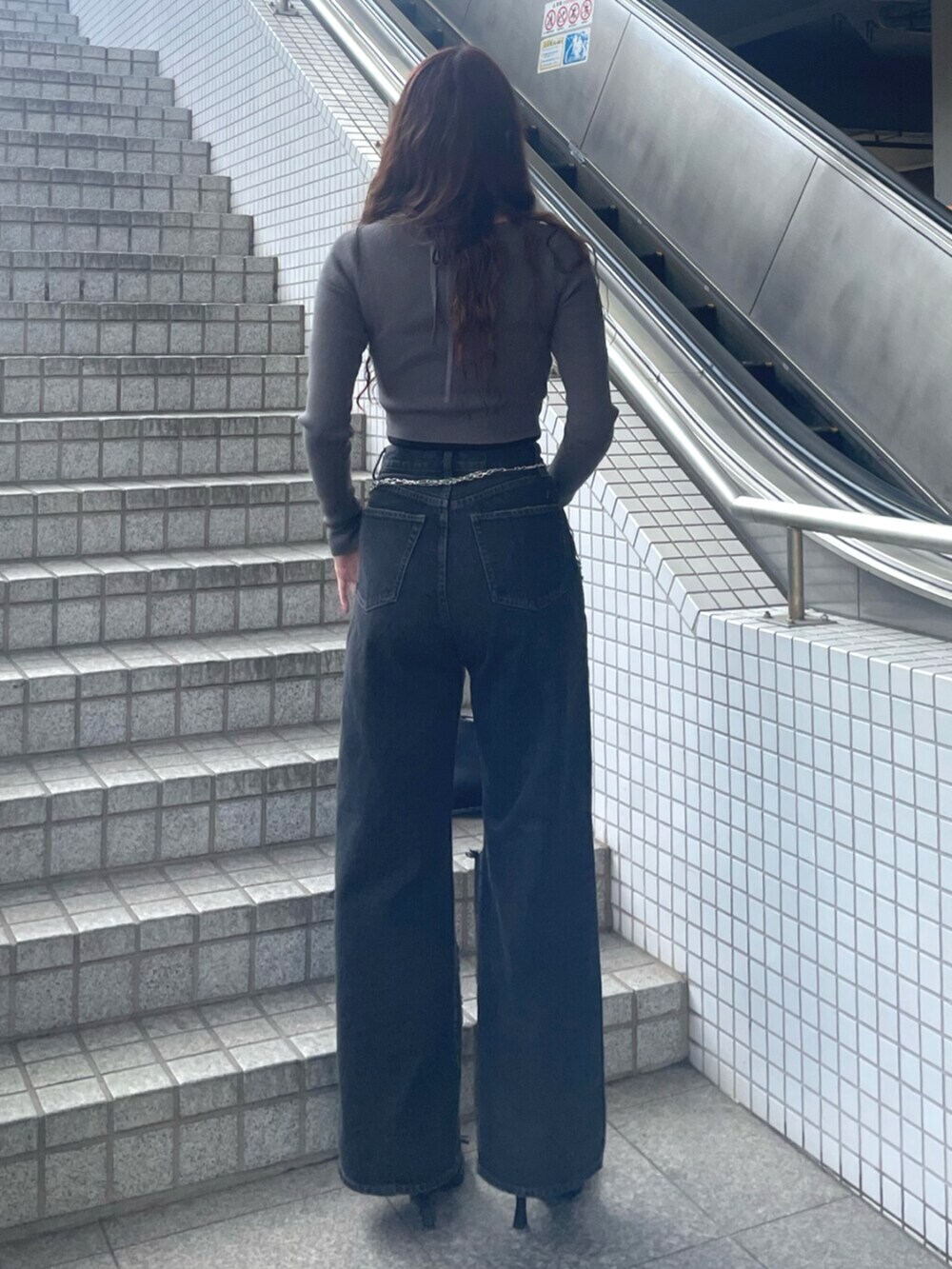 ブラック系のデニムパンツ、ブラック系のハンドバッグ、ブラック系のパンプスを着用したレディースの春コーディネートの3枚目の写真