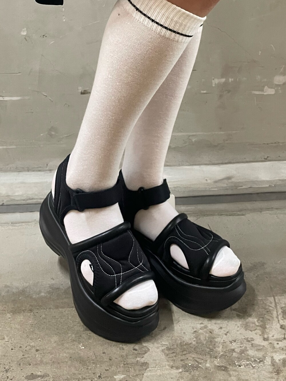 ブラック系のニット/セーター、ブルー系のデニムパンツ、ブラック系のサンダルを着用したレディースの夏コーディネートの10枚目の写真