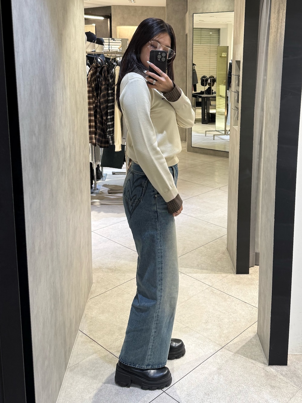 ベージュ系のシャツ/ブラウス、ブルー系のデニムパンツ、ブラック系のブーツを着用したレディースの冬コーディネートの2枚目の写真