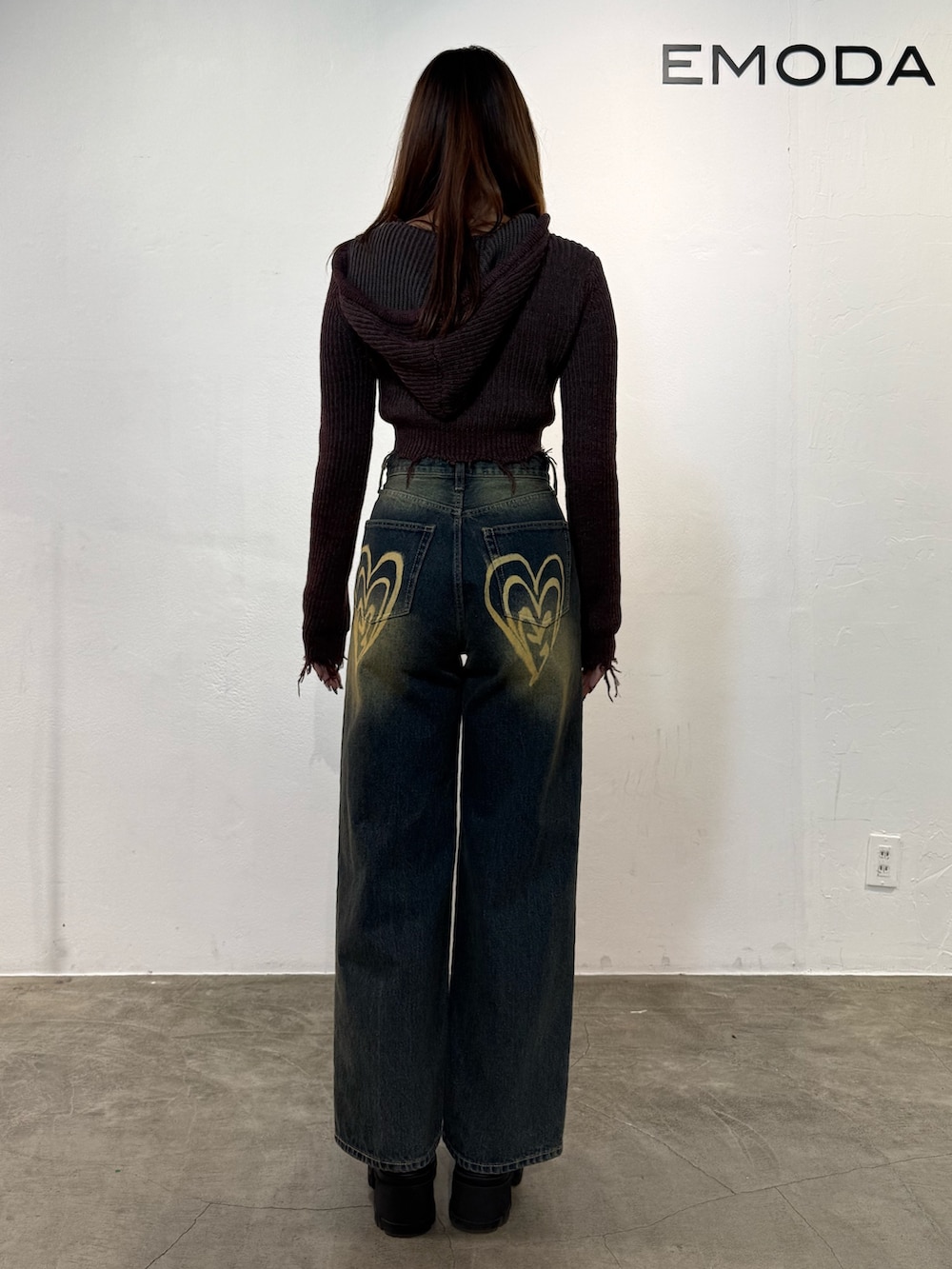 レッド系のニット/セーター、ブルー系のデニムパンツ、ブラック系のブーツを着用したレディースの冬コーディネートの3枚目の写真