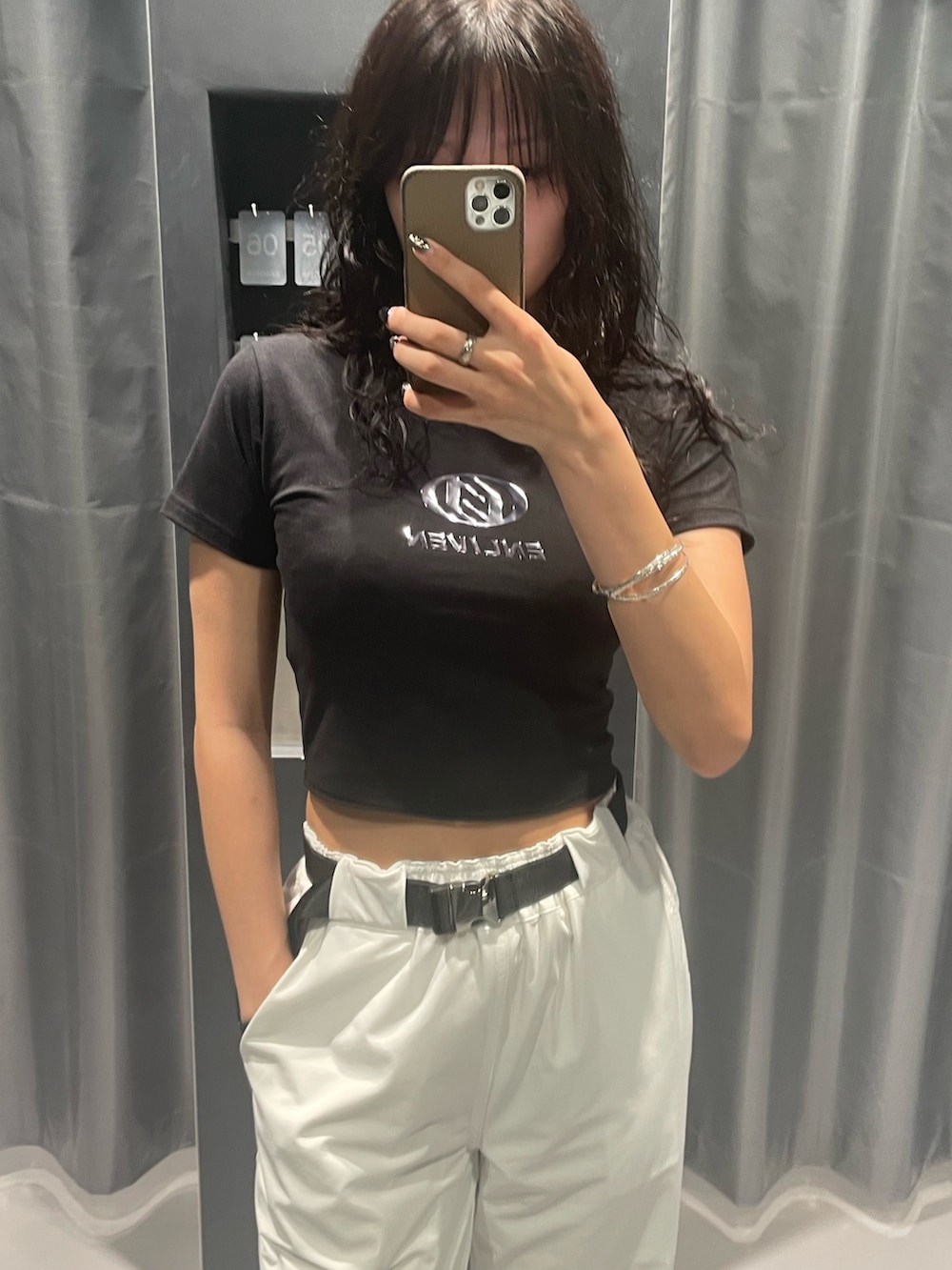 ブラック系のTシャツ/カットソー、ホワイト系のカーゴパンツ、ブラック系のサンダルを着用したレディースの夏コーディネートの4枚目の写真