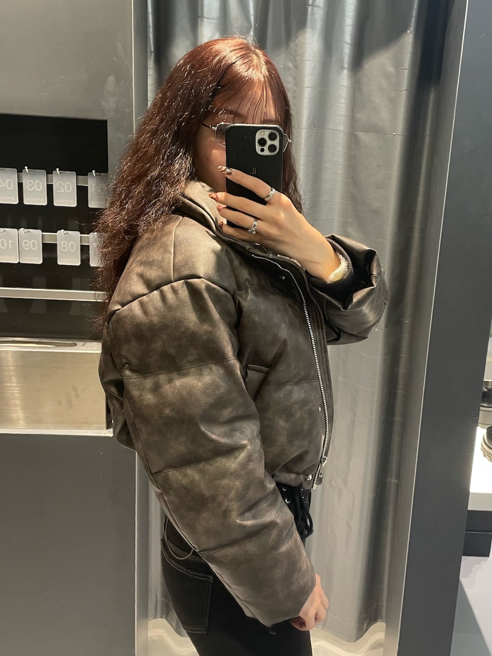 ホワイト系のニット/セーター、ブラウン系のダウンジャケット/コート、ブラック系のデニムパンツを着用したレディースの冬コーディネートの5枚目の写真