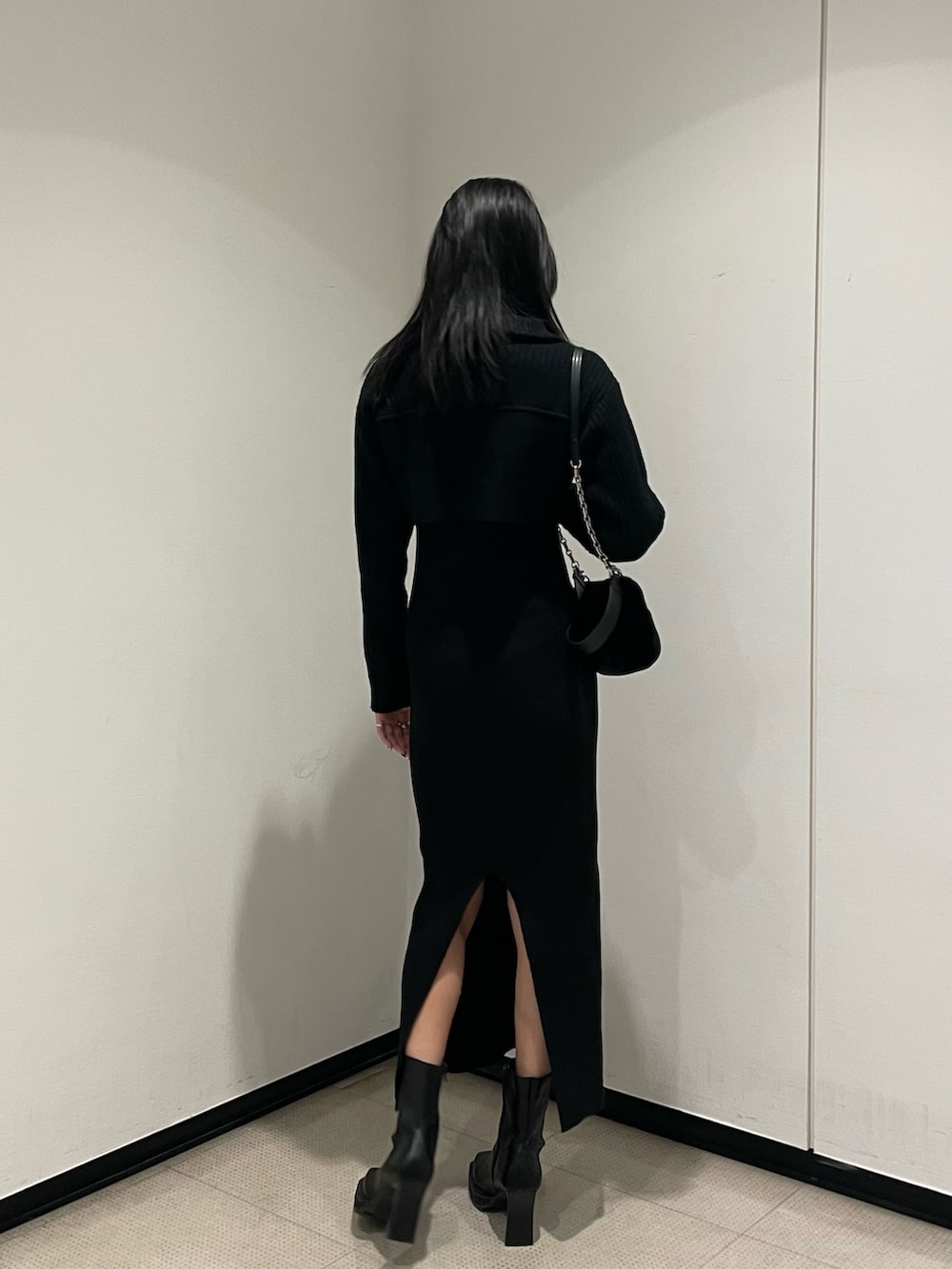 ブラック系のワンピース、ブラック系のハンドバッグ、ブラック系のブーツを着用したレディースの秋コーディネートの3枚目の写真