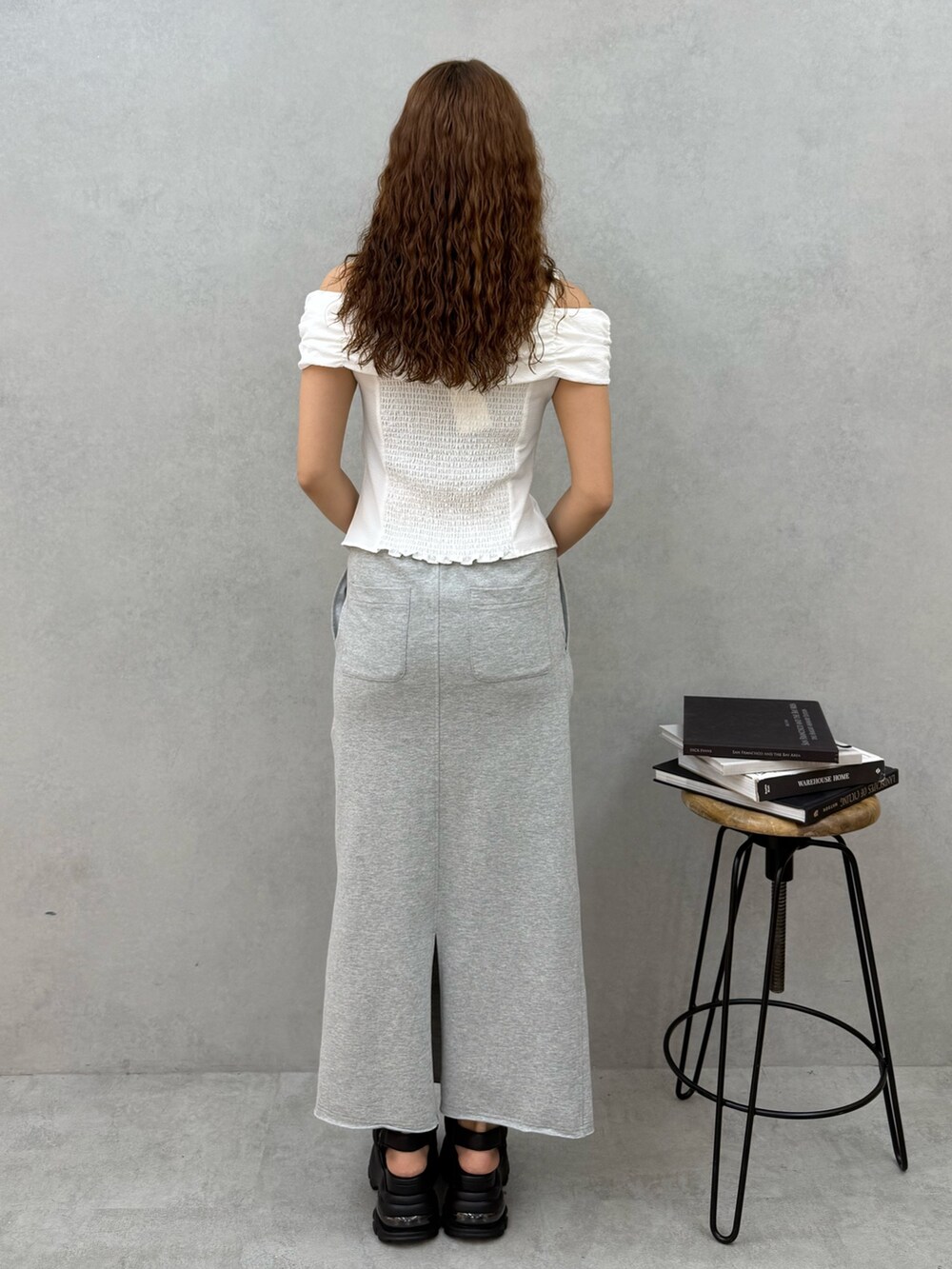 ホワイト系のTシャツ/カットソー、グレー系のスカート、ブラック系のサンダルを着用したレディースの夏コーディネートの3枚目の写真