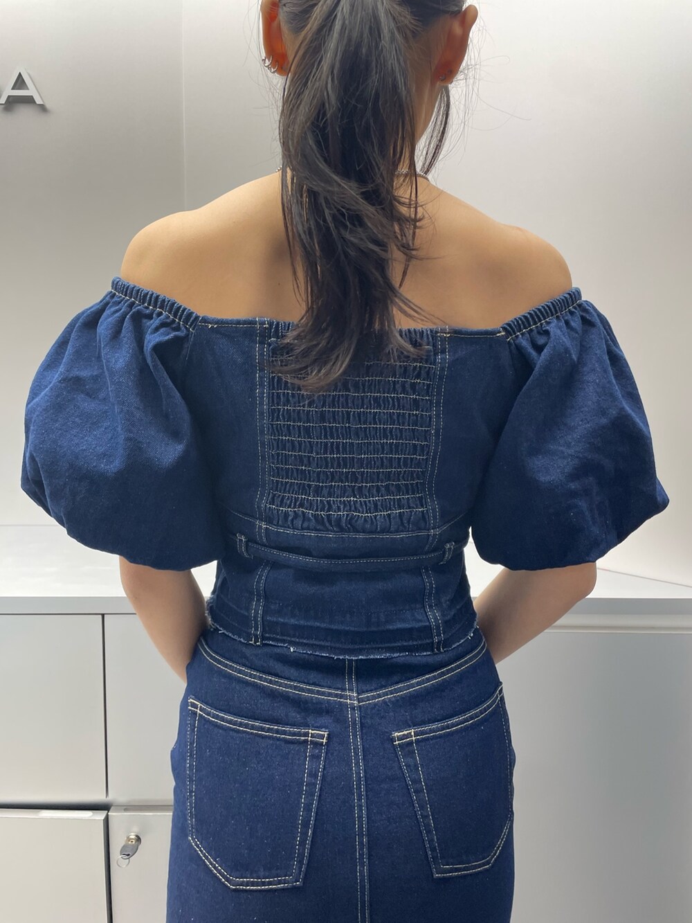 ブルー系のシャツ/ブラウス、ブルー系のスカート、ブラック系のハンドバッグを着用したレディースの春コーディネートの6枚目の写真