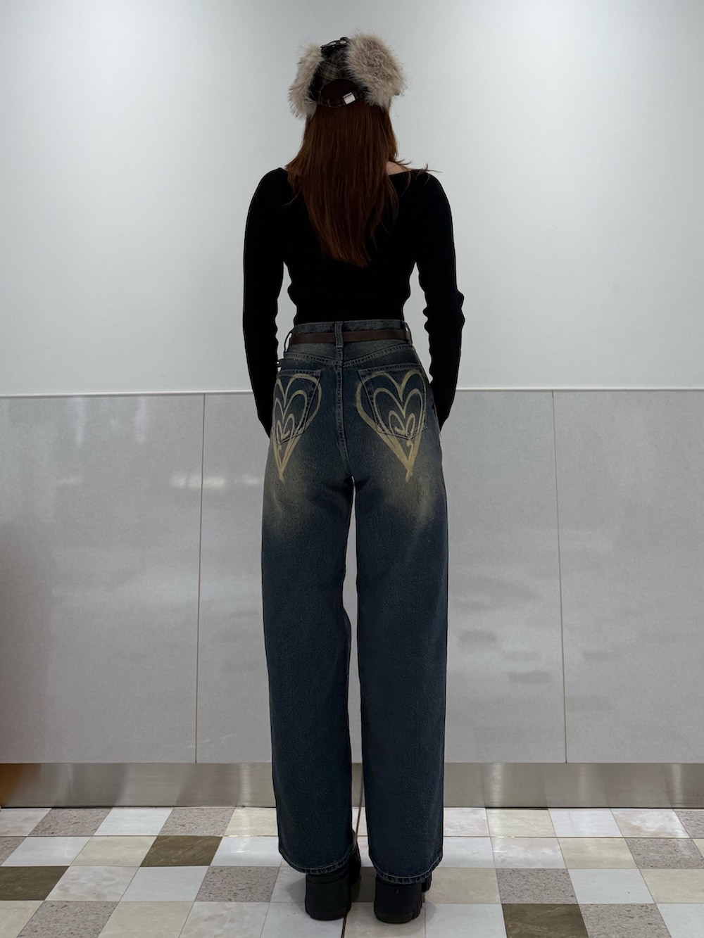 ブラック系のニット/セーター、ブルー系のデニムパンツ、ブラック系のブーツを着用したレディースの冬コーディネートの3枚目の写真