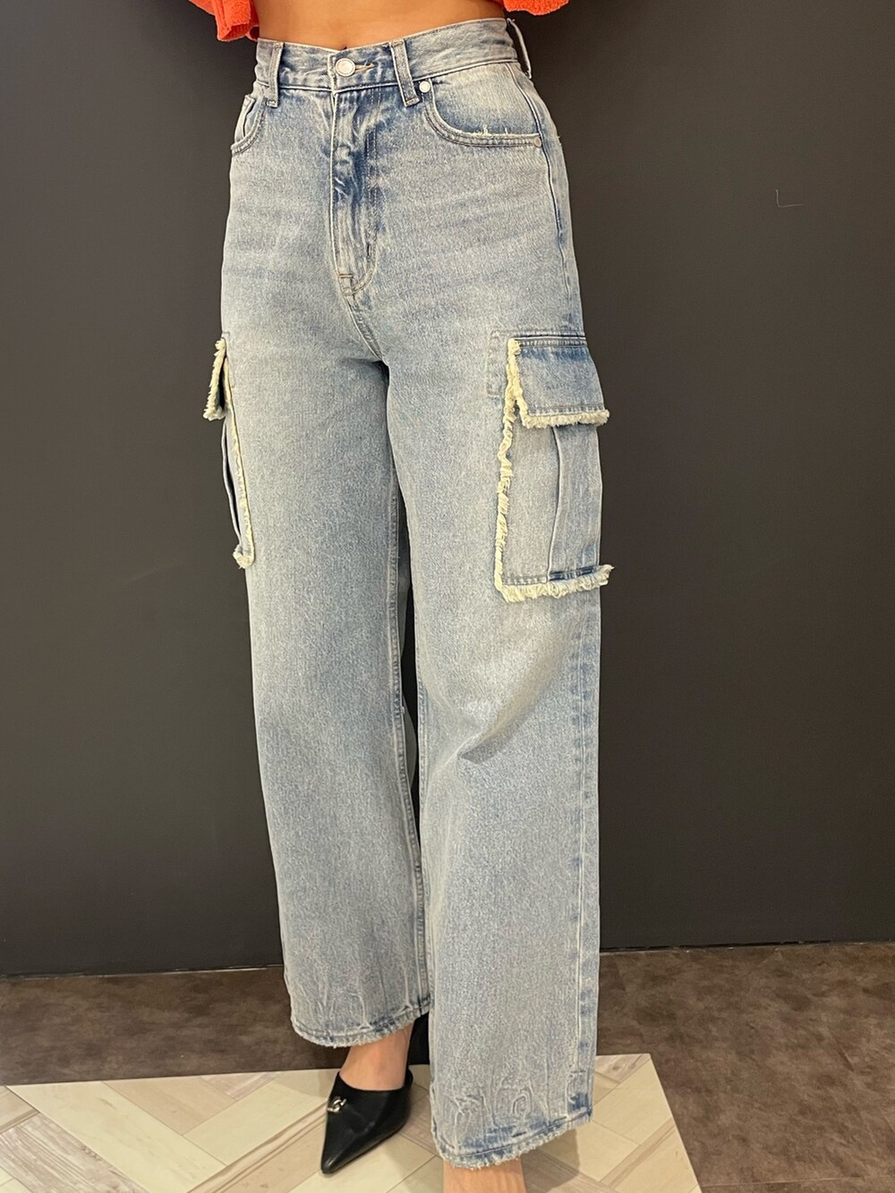 オレンジ系のニット/セーター、ブルー系のデニムパンツ、ブラック系のパンプスを着用したレディースの春コーディネートの7枚目の写真