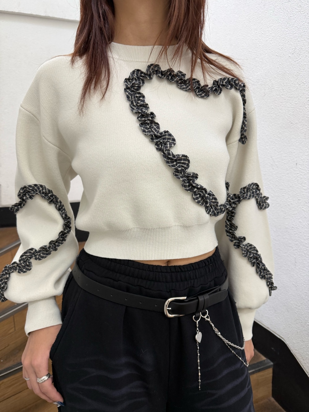 ホワイト系のニット/セーター、ブラック系のスウェットパンツ、ブラック系のブーツを着用したレディースの冬コーディネートの4枚目の写真