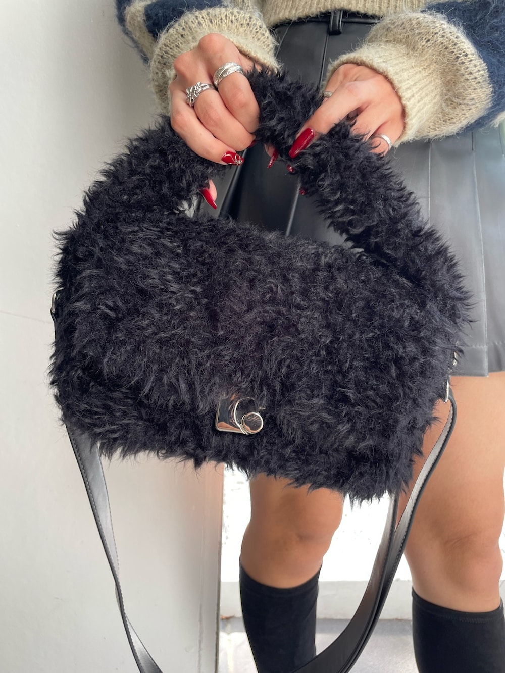 ブルー系のニット/セーター、ブラック系のスカート、ブラック系のハンドバッグを着用したレディースの秋コーディネートの8枚目の写真