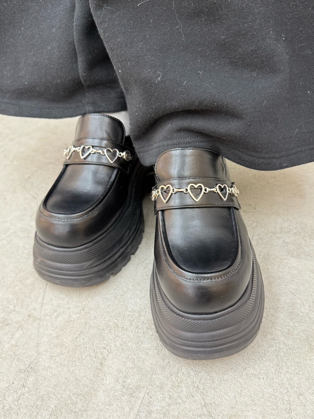 ブラック系のパーカー、ブラック系のスウェットパンツ、ブラック系のローファーを着用したレディースの冬コーディネートの6枚目の写真