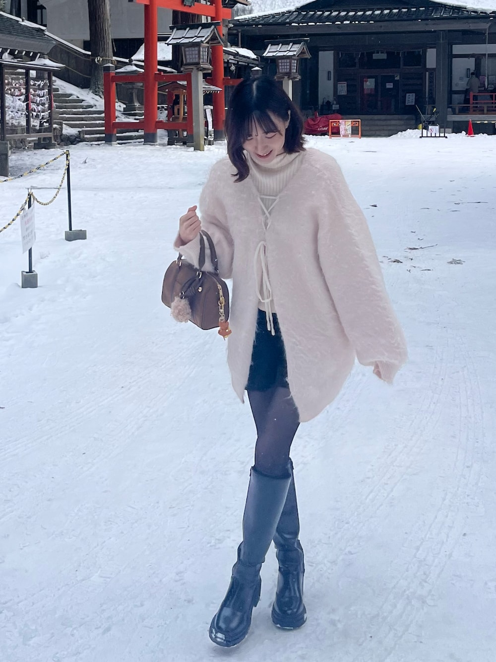 ピンク系のカーディガン/ボレロ、ホワイト系のニット/セーター、ブラック系のその他パンツを着用したレディースの冬コーディネートの2枚目の写真