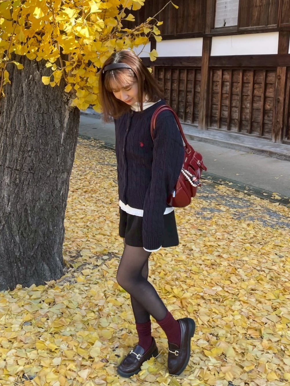 レッド系のショルダーバッグ、その他のカーディガン/ボレロ、ブラック系のその他パンツを着用したレディースの冬コーディネートの2枚目の写真