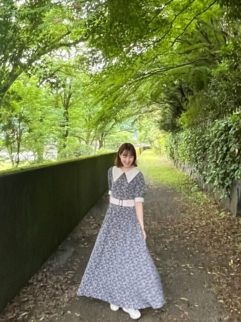 ブルー系のワンピース、ホワイト系のスニーカーを着用したレディースの夏コーディネートの3枚目の写真