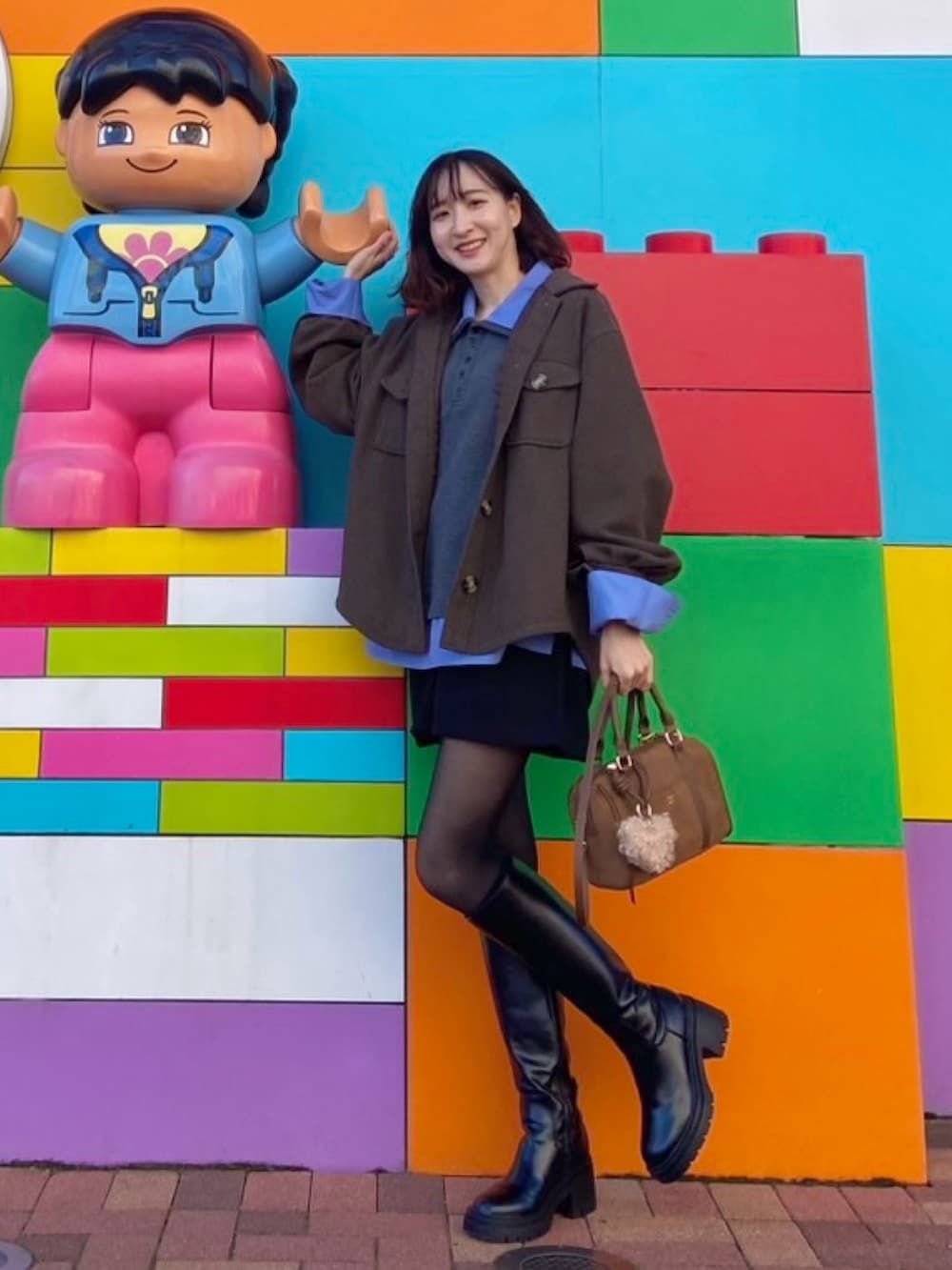 イエロー系のボストンバッグ、ブラック系のその他パンツ、ブルー系のシャツ/ブラウスを着用したレディースの春コーディネートの2枚目の写真