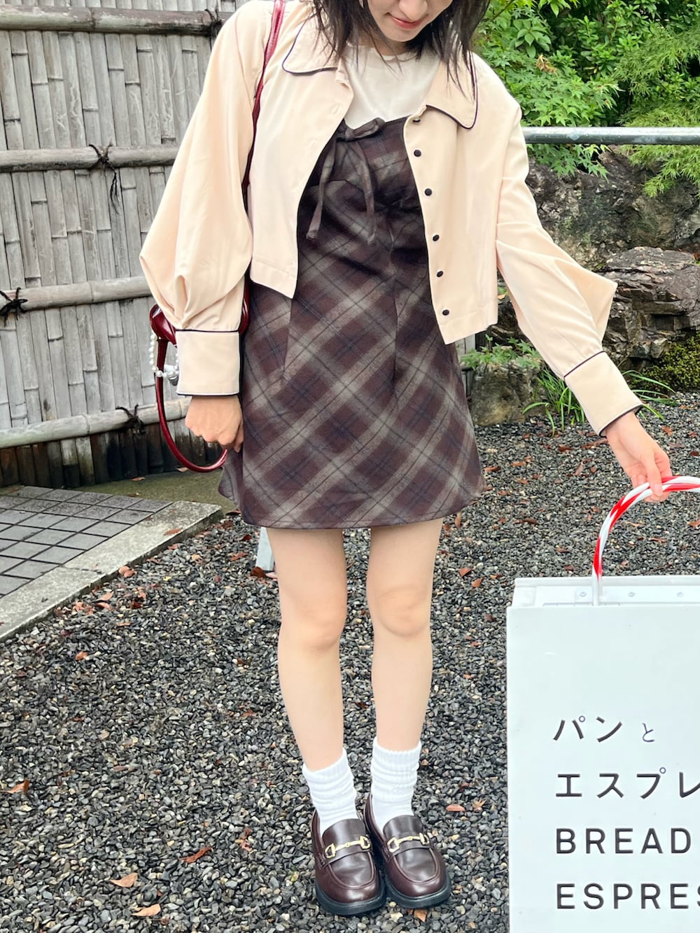 ベージュ系のナイロンジャケット、ブラウン系のワンピースを着用したレディースの秋コーディネートの2枚目の写真