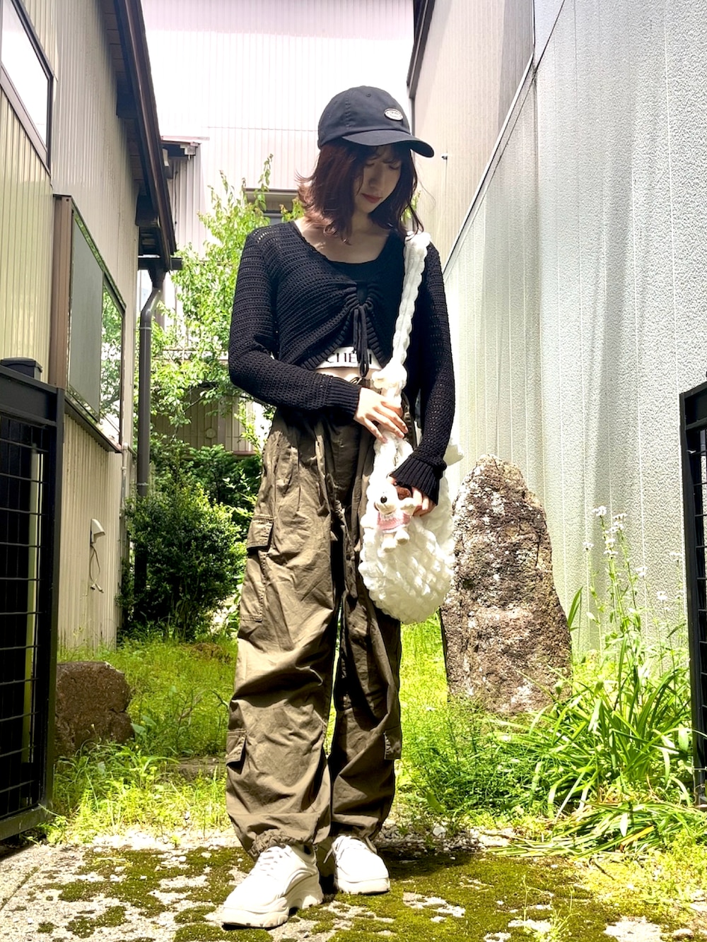 グリーン系のカーゴパンツ、ブラック系のシャツ/ブラウス、ホワイト系のトートバッグを着用したレディースの春コーディネートの2枚目の写真