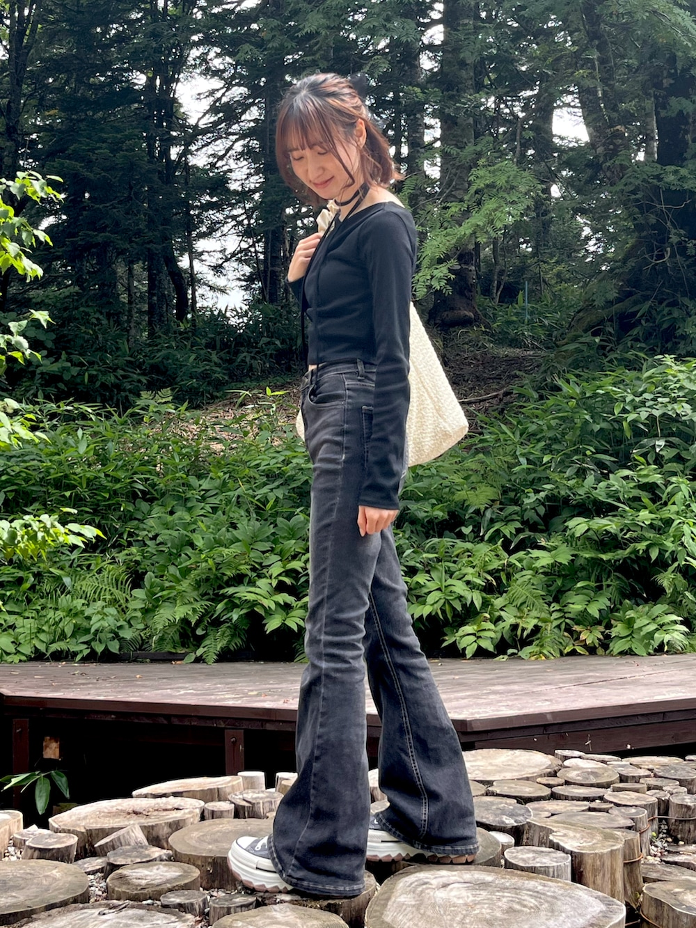 グレー系のデニムパンツ、グレー系のスニーカー、ブラック系のTシャツ/カットソーを着用したレディースの夏コーディネートの2枚目の写真