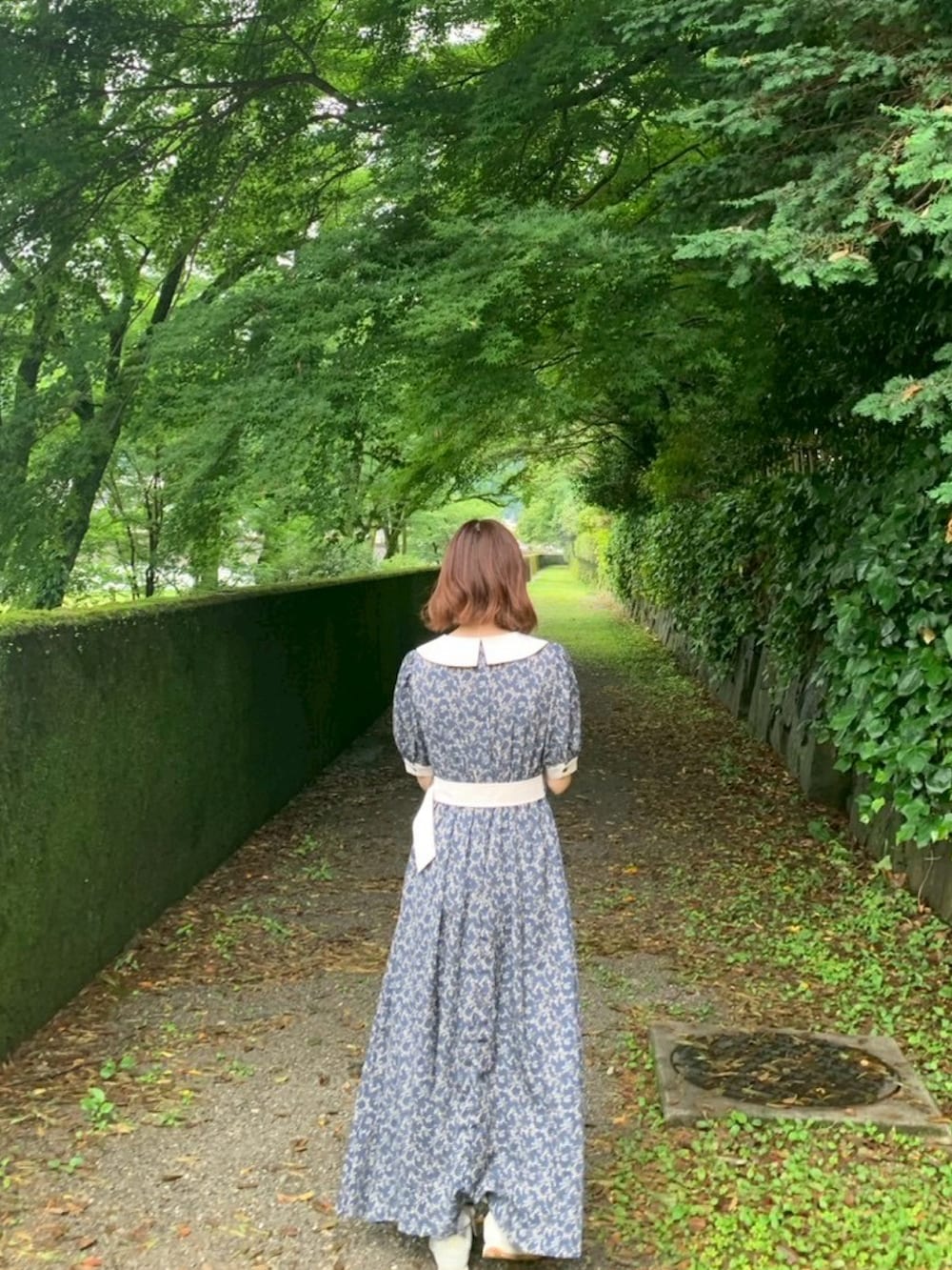 ブルー系のワンピース、ホワイト系のスニーカーを着用したレディースの夏コーディネートの2枚目の写真