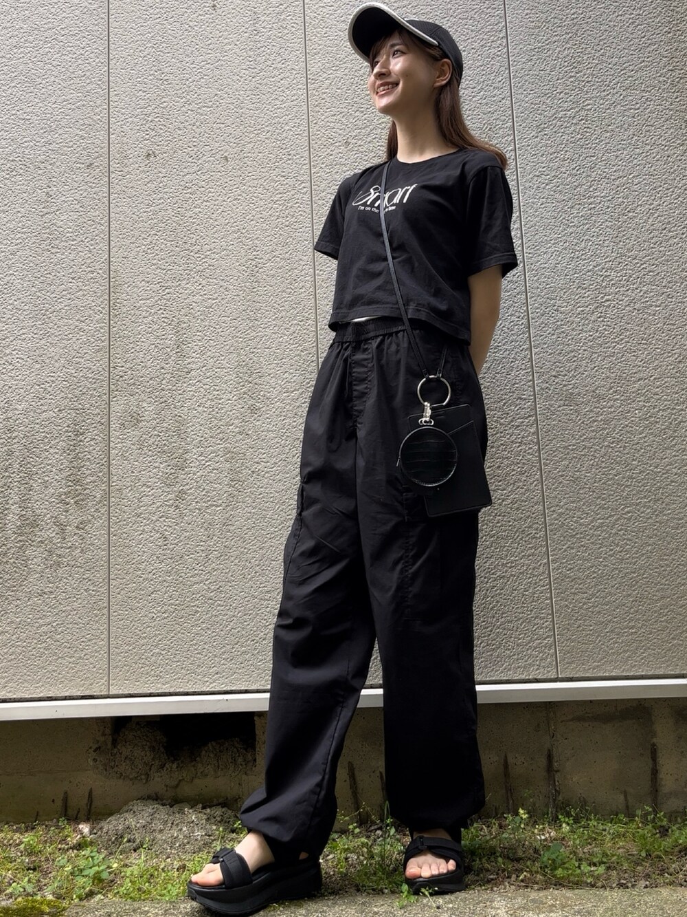 ブラック系のカーゴパンツ、ブラック系のショルダーバッグ、ブラック系のTシャツ/カットソーを着用したレディースの夏コーディネートの2枚目の写真