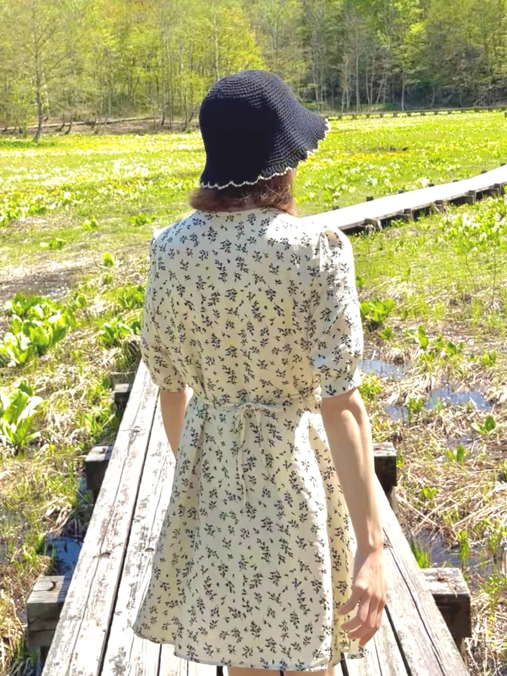 ホワイト系のスニーカー、ホワイト系のワンピースを着用したレディースの夏コーディネートの2枚目の写真