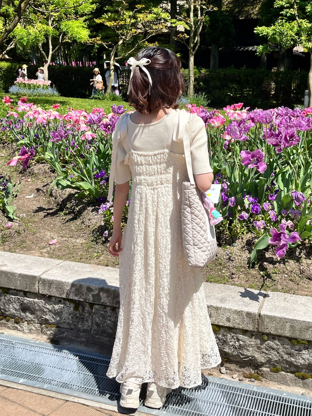 ホワイト系のワンピース、ホワイト系のスニーカーを着用したレディースの春コーディネートの2枚目の写真