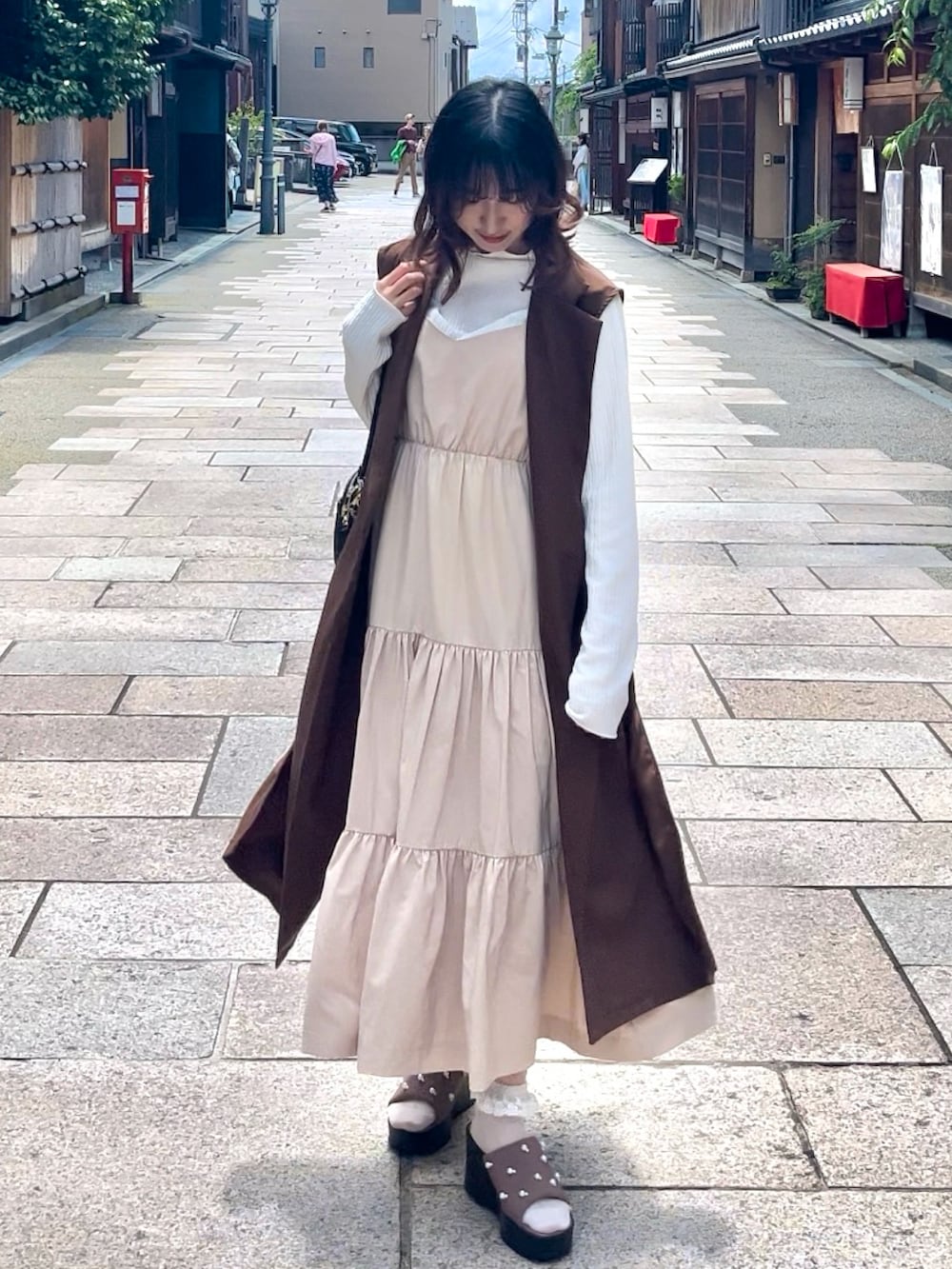 ベージュ系のワンピース、ホワイト系のシャツ/ブラウス、ピンク系のサンダルを着用したレディースの夏コーディネートの2枚目の写真