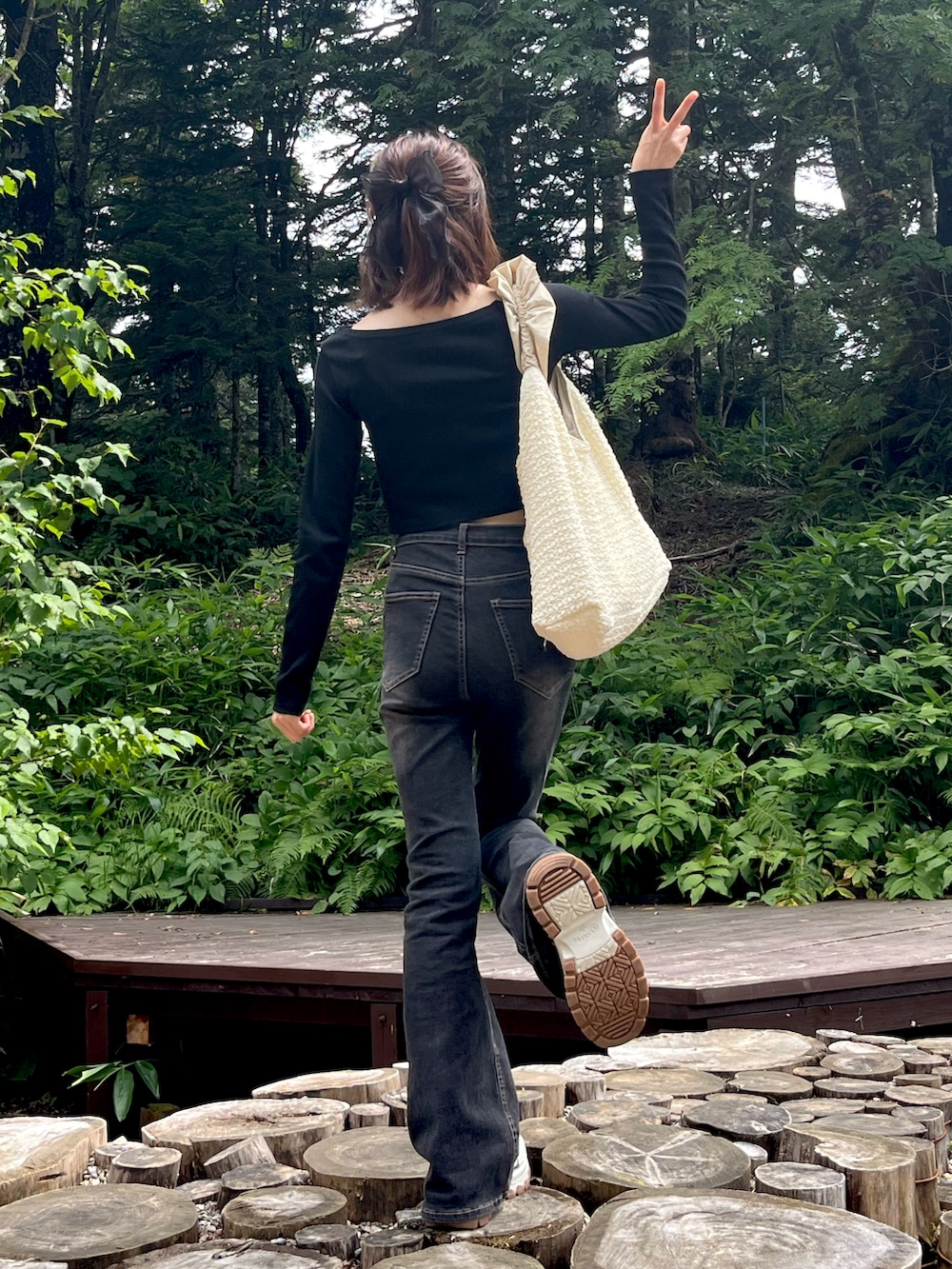 グレー系のデニムパンツ、グレー系のスニーカー、ブラック系のTシャツ/カットソーを着用したレディースの夏コーディネートの3枚目の写真