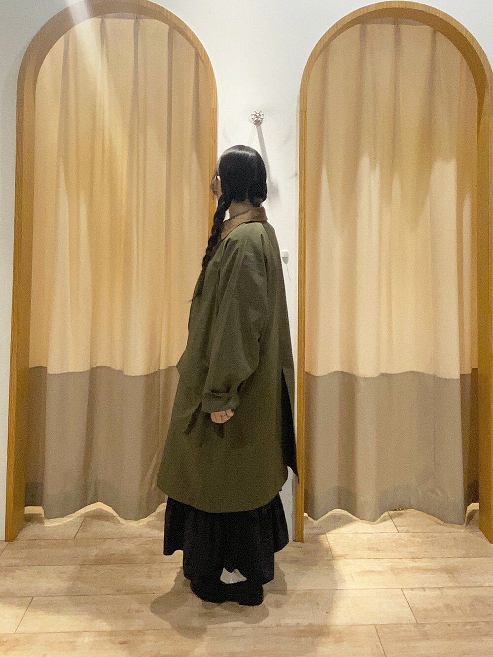 グレー系のTシャツ/カットソー、ブラック系のスカート、グリーン系のその他アウターを着用したレディースの秋コーディネートの2枚目の写真