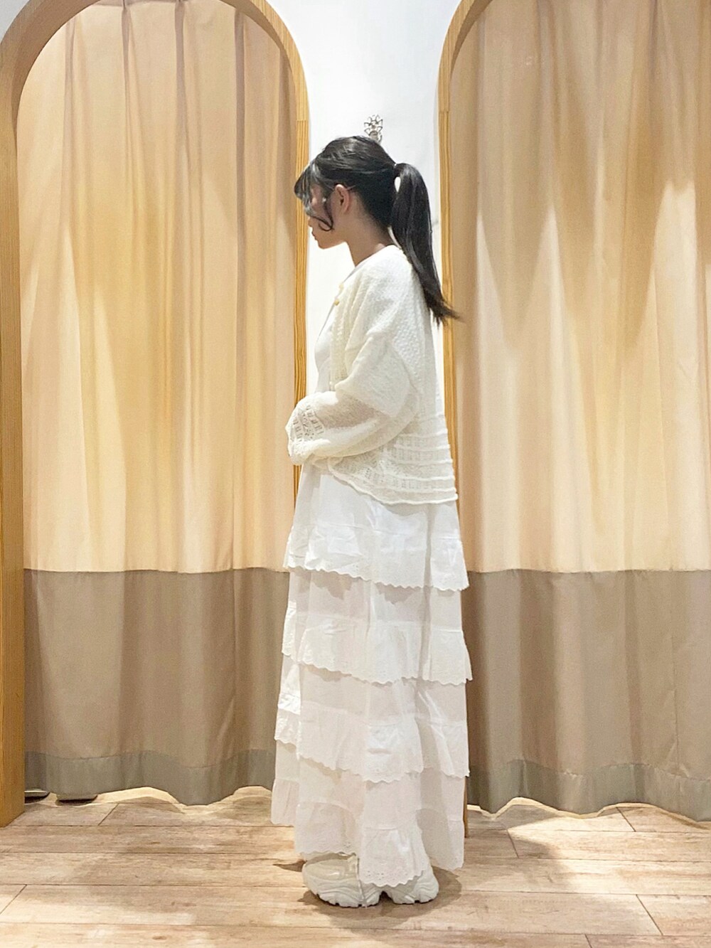 ホワイト系のワンピース、ホワイト系のカーディガン/ボレロ、ホワイト系のスニーカーを着用したレディースの春コーディネートの2枚目の写真